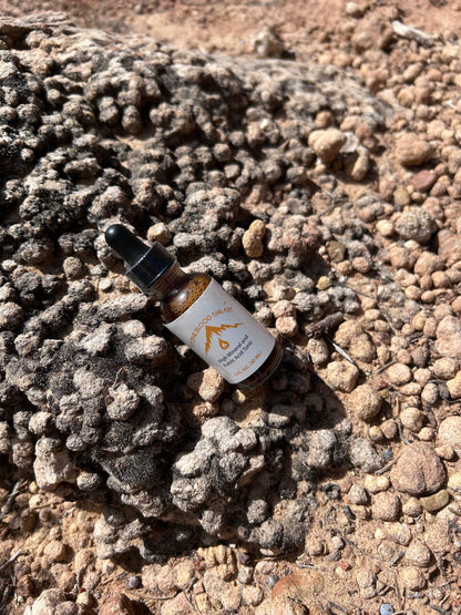 Stoneblood Shilajit dropper bottle resting on raw mineral resin rock, wildcrafted in the Utah desert